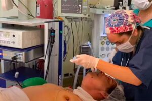 オッパイ丸出しの熟女が口腔内に何かを挿入されている動画