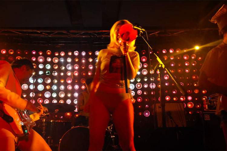 日本人の女性ボーカルがパンツ姿で熱唱するバンドのライブ映像